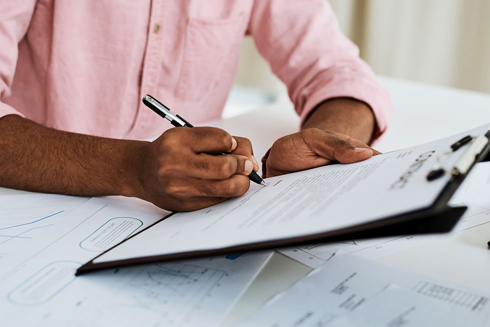 man signing papers