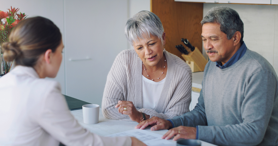 Older couple going over paperwork with specialist