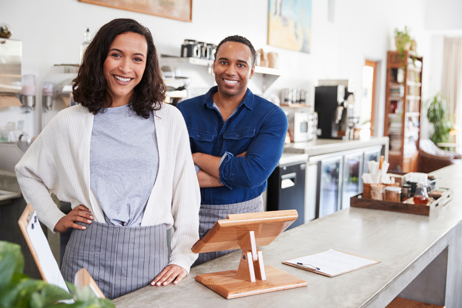 Man and woman standing behind the counter of a small business.